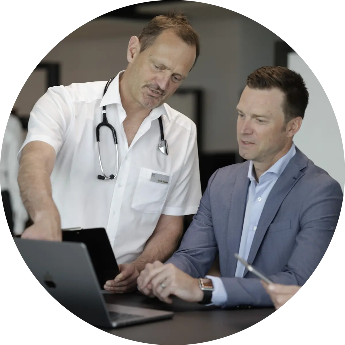 Arzt erklärt einem Patienten am Laptop dessen Laborwerte